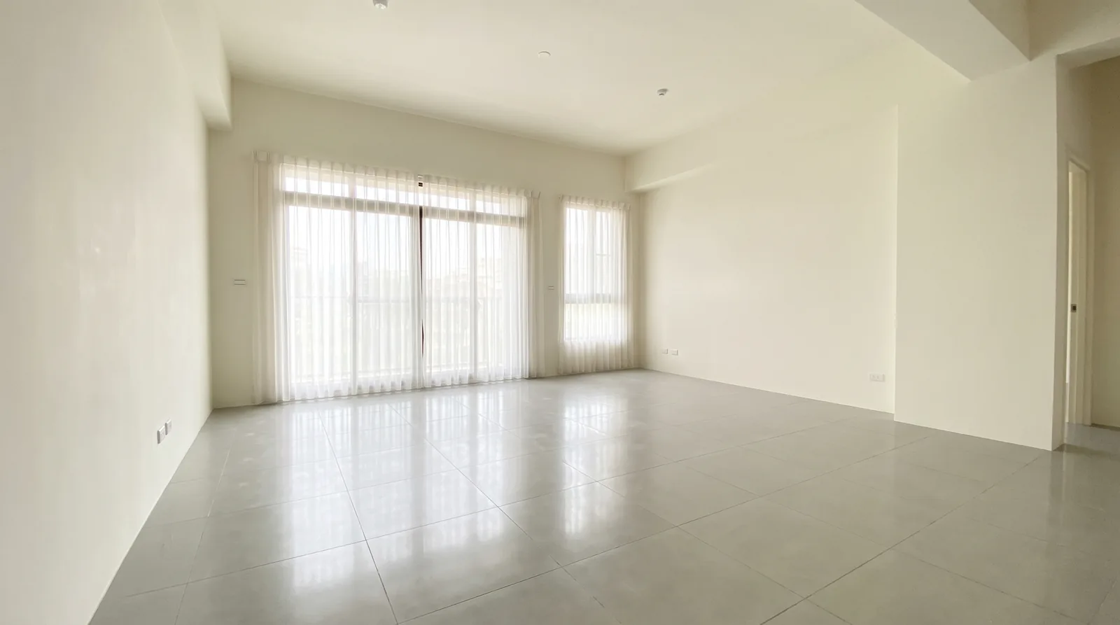 Empty, clean residential living room with bare floor and natural light after remediation